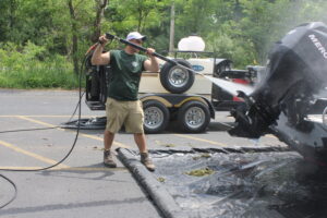 El personal del proyecto lava un barco y habla con los navegantes sobre cómo detener la propagación de especies invasoras en el condado de Jackson, Michigan.